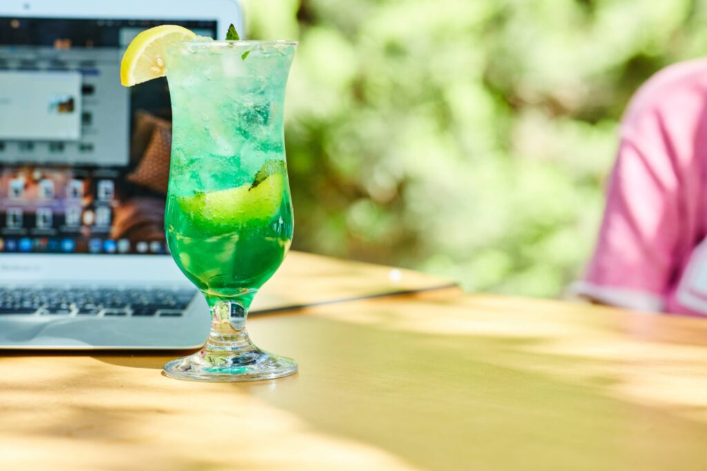 A fruit lemonade next to laptop on wooden table
